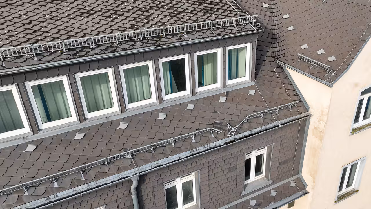 drohnenaufnahme eines beschädigten hausdachs mit dachschindeln und schneefanggitter in frankfurt