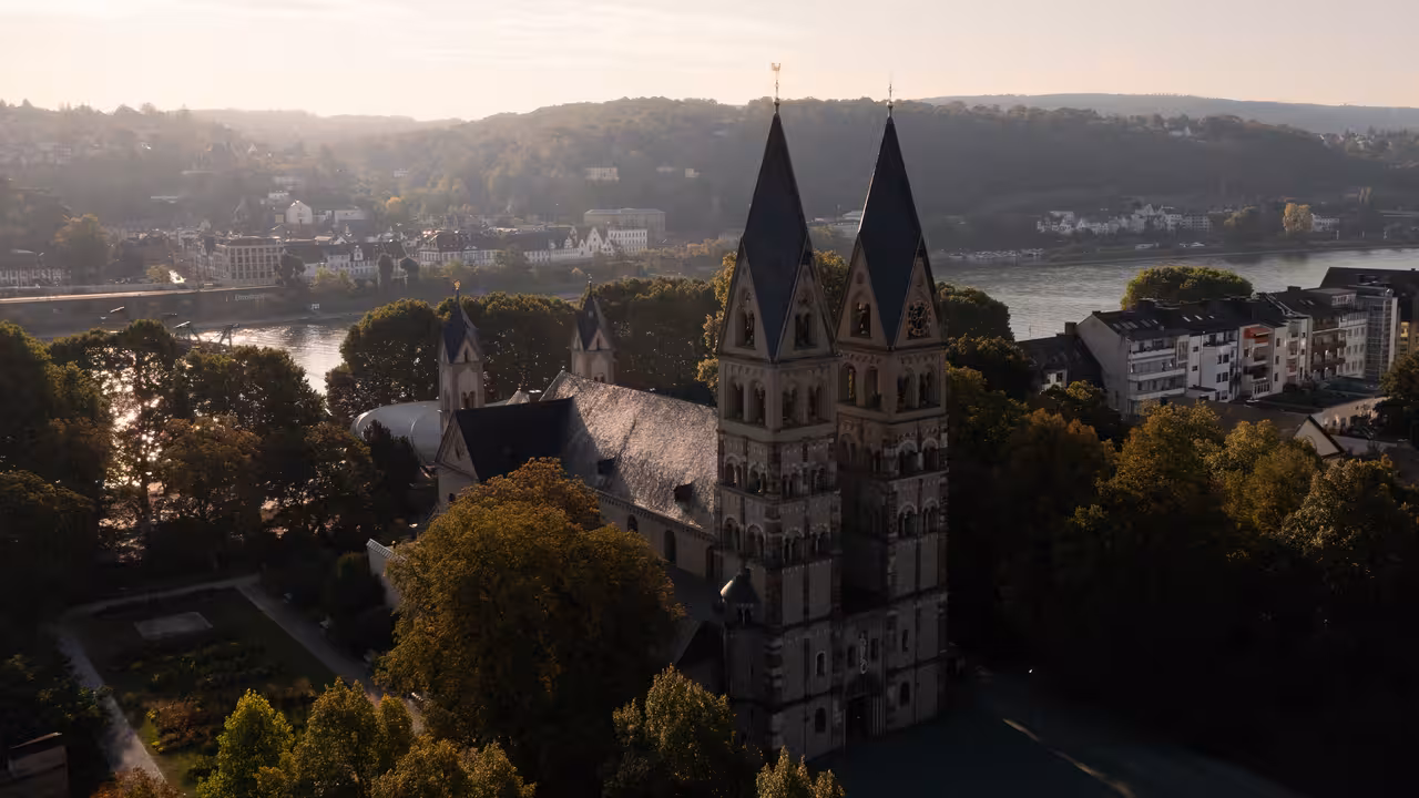 drohnenaufnahme der basilika sankt kastor am rheinufer in koblenz in der morgensonne