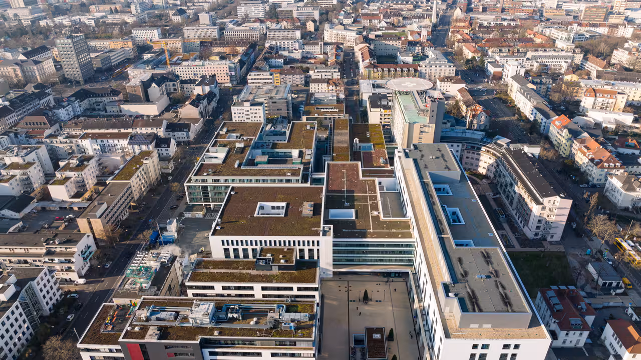 drohnenaufnahme des klinikums mit dem umliegenden stadtgebiet in darmstadt in der morgensonne