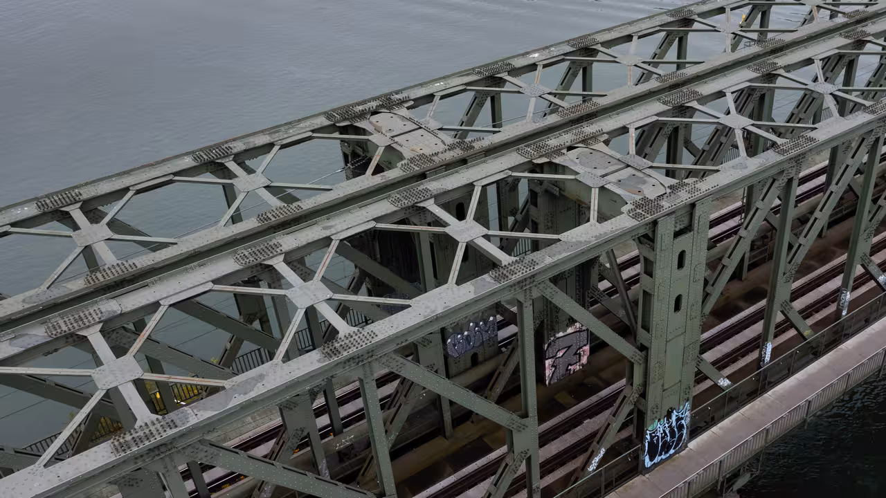drohnenaufnahme des obergurts einer stahlfachwerkbrücke für eisenbahn- und fußverkehr über den rhein in mainz