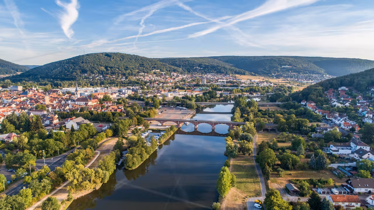 drohnenaufnahme der altstadt mit neuer und alter mainbrücke in lohr am main in der morgensonne