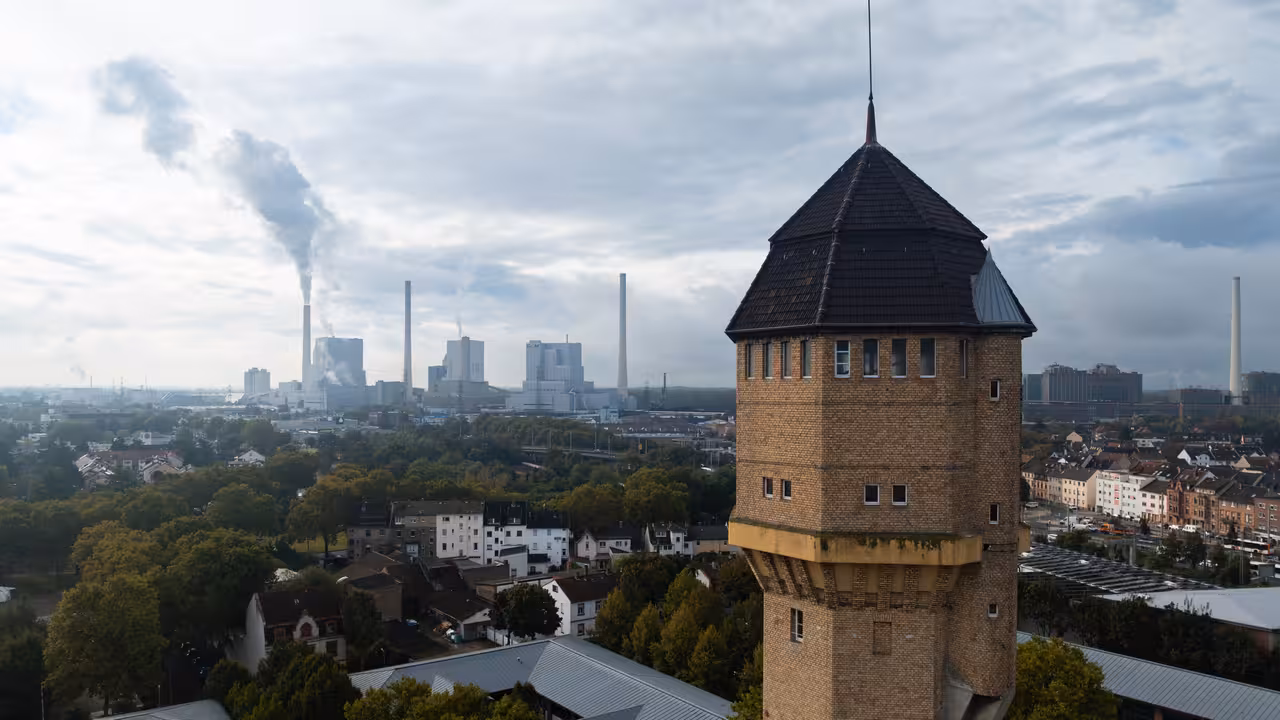 drohnenaufnahme eines wasserturms mit industrieanlagen im hintergrund in mannheim