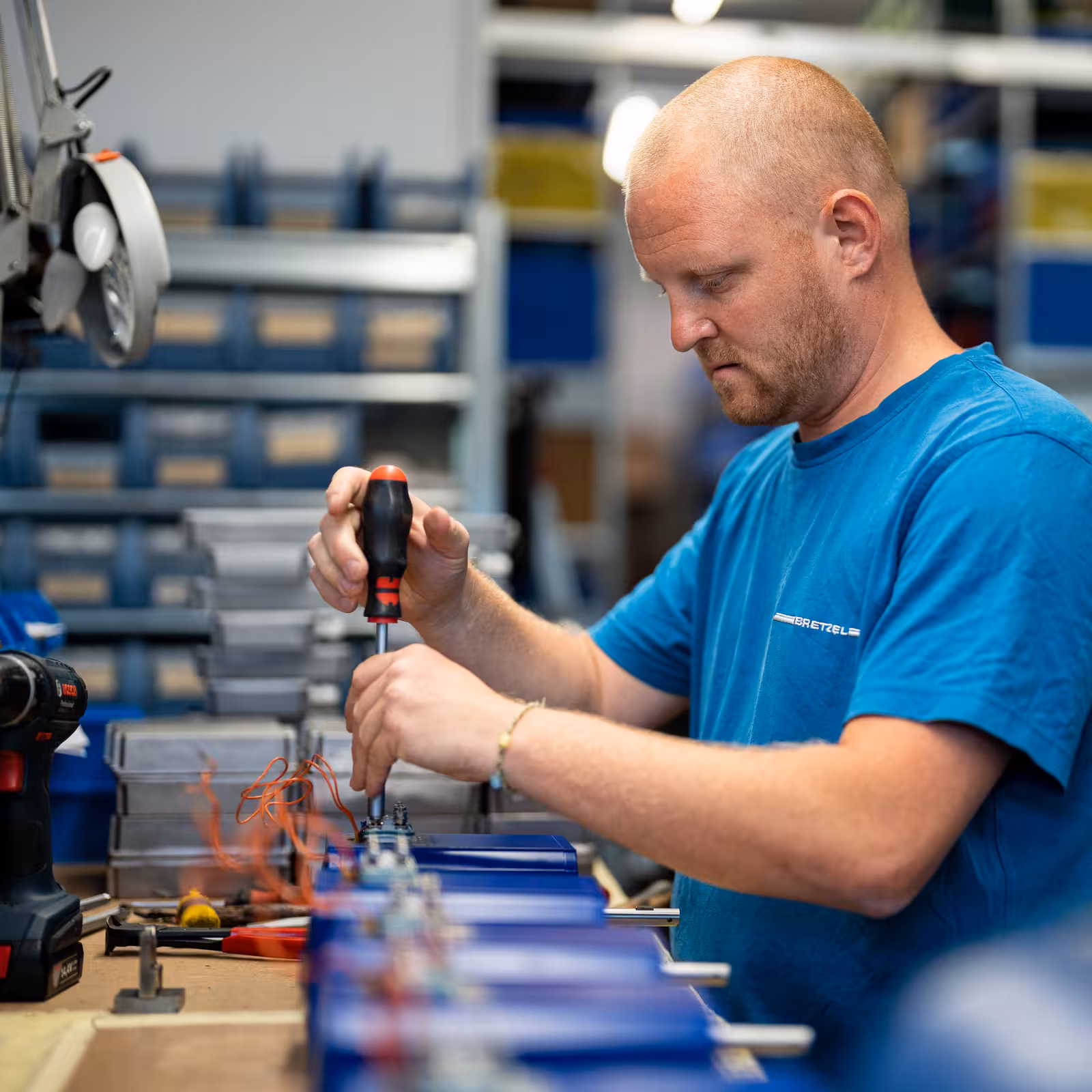 teleaufnahme eines mitarbeiters mit schraubendreher bei der reparatur eines elektromotors bei bretzel in weiterstadt für marketing