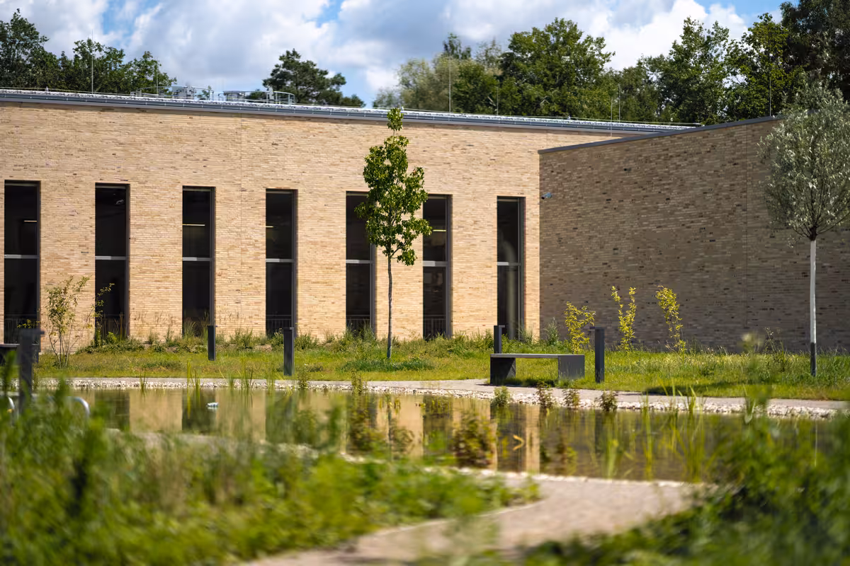 teleaufnahme des innenhofs mit grünanlagen und teich eines wasserwerks in münster für immobilienmarketing
