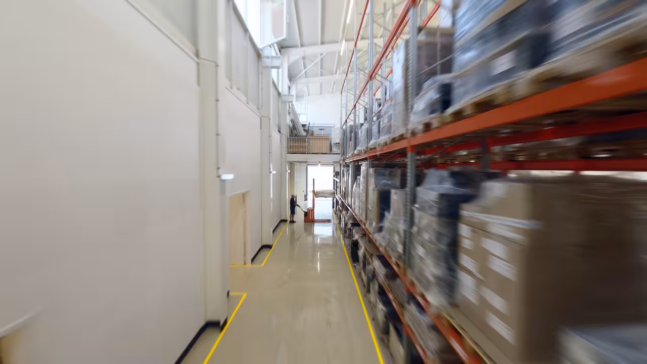 fpv drohnenaufnahme während des flugs durch eine moderne logistikhalle