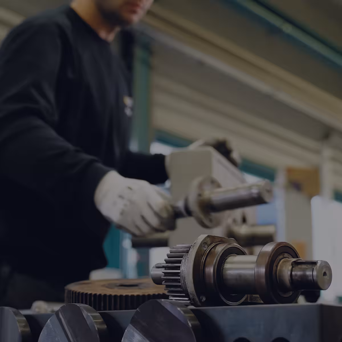 teleaufnahme eines mitarbeiters bei der reparatur eines getriebes bei maag in großostheim für einen imagefilm dunkel