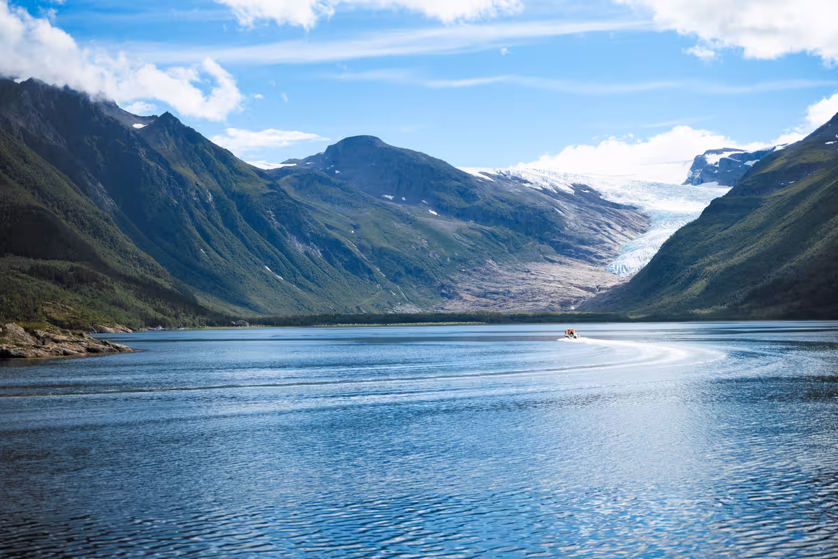 drohnenaufnahme eines fjords mit gletscher in norwegen bei sonnenschein