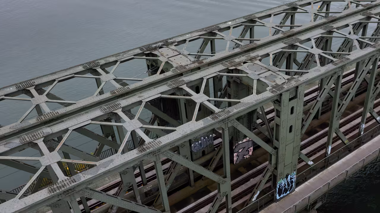 drohnenaufnahme einer stahlfachwerk-eisenbahnbrücke mit nietverbindungen über den rhein in mainz