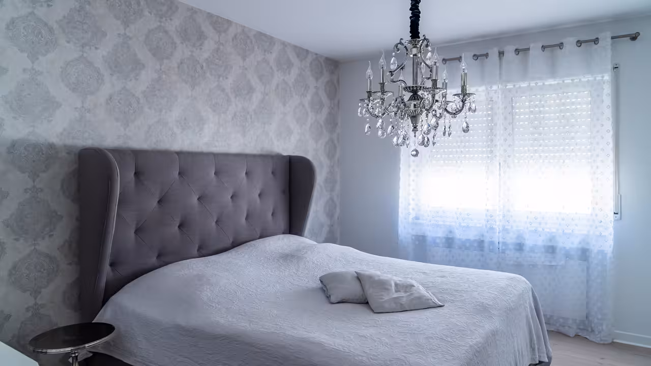 weitwinkelaufnahme des schlafzimmers einer modern eingerichteten wohnung in frankfurt am main mit hellem lichteinfall für immobilienmarketing