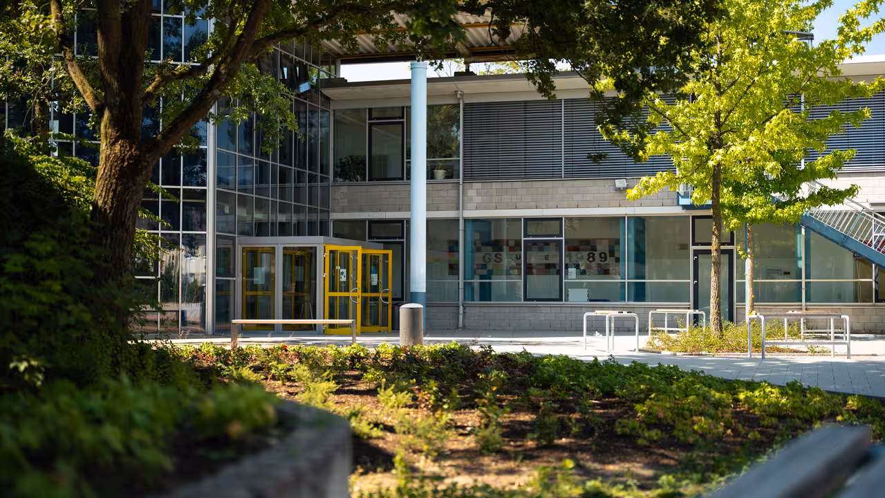 teleaufnahme des eingangs des städtischen gymnasiums mit grünanlagen im vordergrund in selm