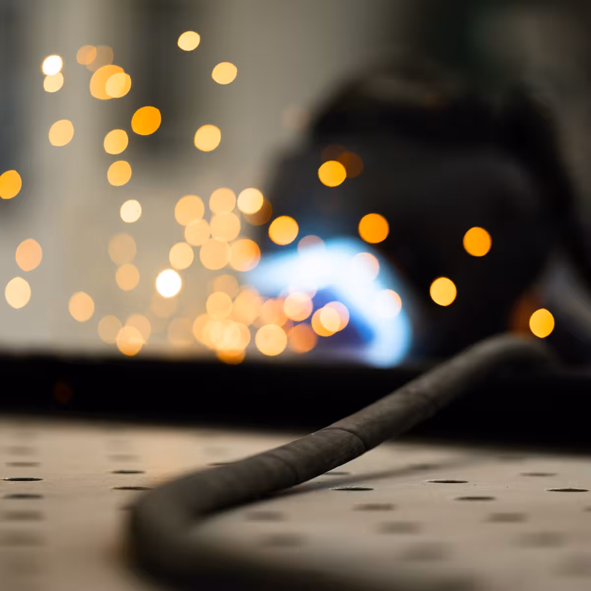 teleaufnahme eines mitarbeiters beim stahlschweißen mit funken im hintergrund bei korema in darmstadt für einen imagefilm