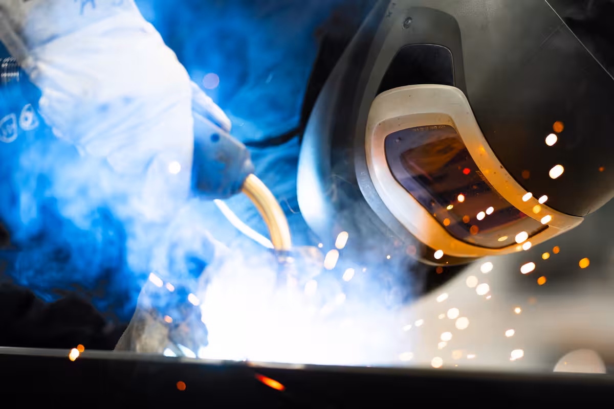 teleaufnahme eines mitarbeiters beim stahlschweißen mit funken im vordergrund bei korema in darmstadt für social media