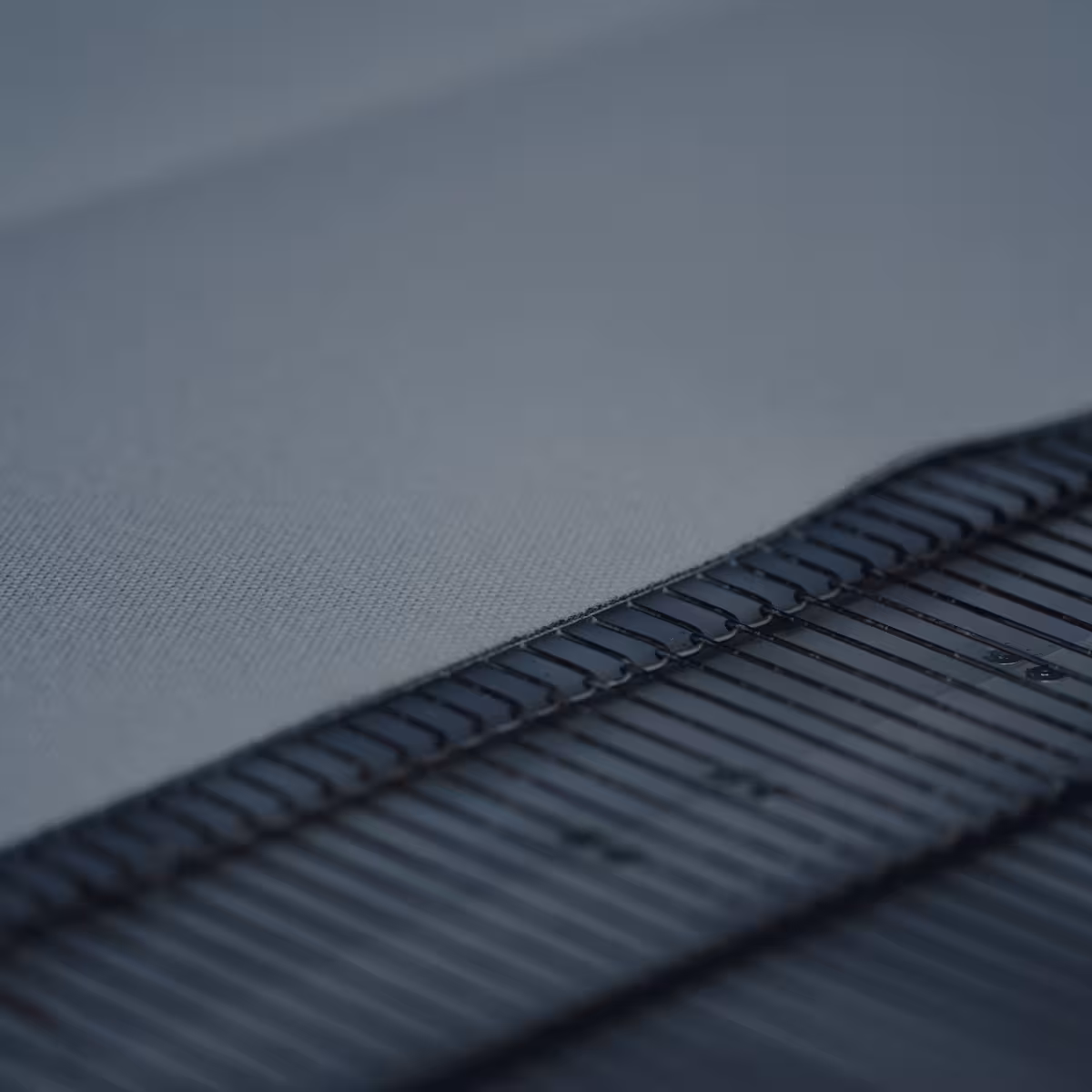 teleaufnahme der schnittkante eines glasfasergewebes auf einem förderband bei korema in darmstadt für einen imagefilm dunkel