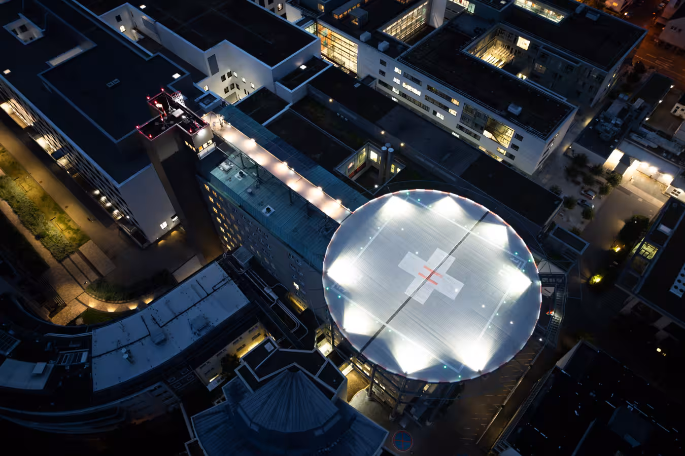 drohnenaufnahme des bei nacht beleuchteten hubschrauberlandeplatzes des klinikums in darmstadt